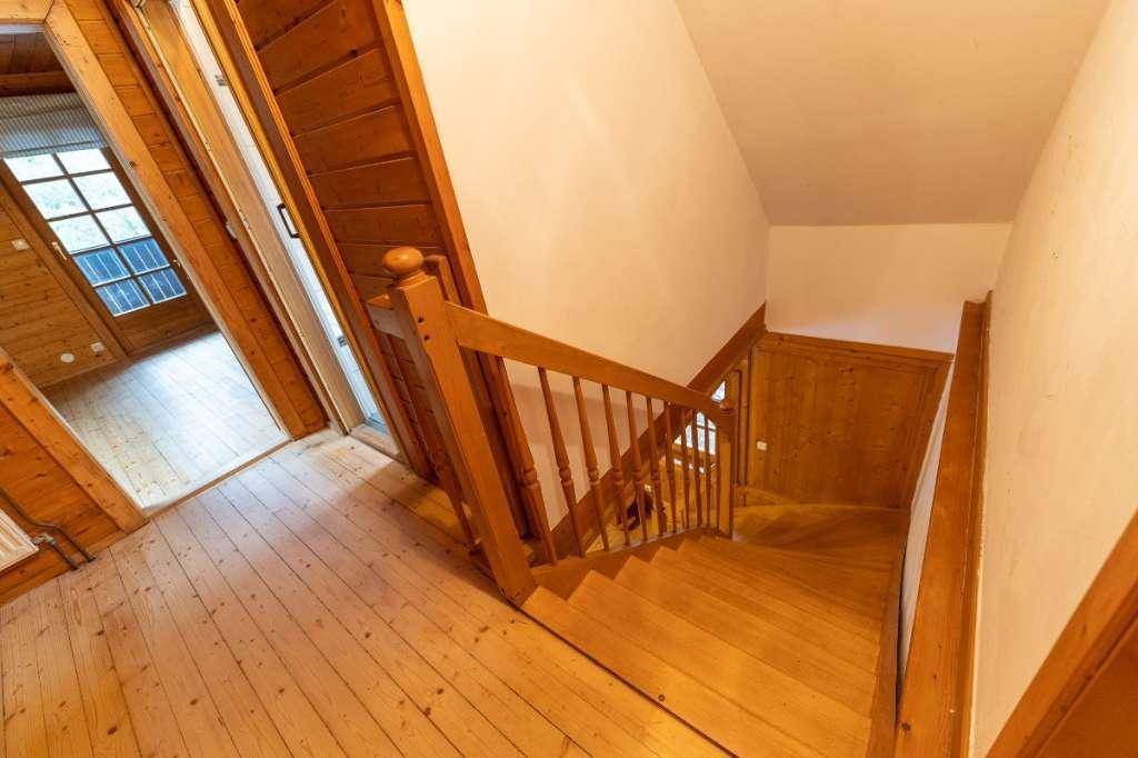 Rustikale Holztreppe verbindet die Stockwerke in diesem traditionellen Haus mit Holzvertäfelung.