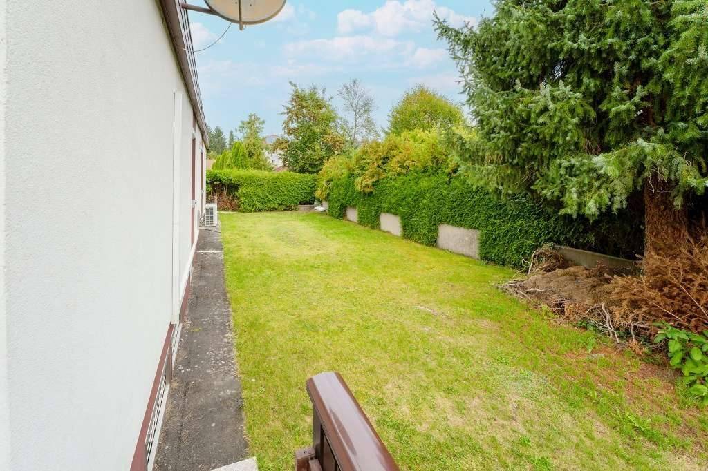 Gepflegter Garten mit Rasenfläche und hohen Hecken, bietet viel Platz im Grünen.
