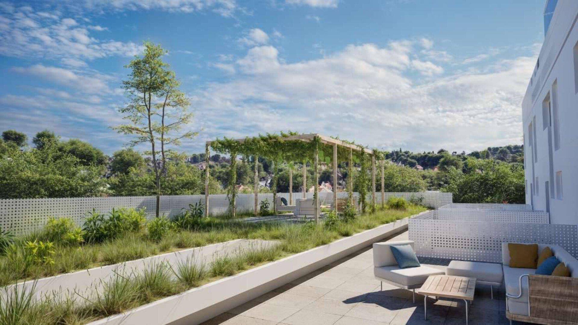 Grüne Dachterrasse mit Pergola, bequemen Sitzgelegenheiten und weitem Blick in die Natur.
