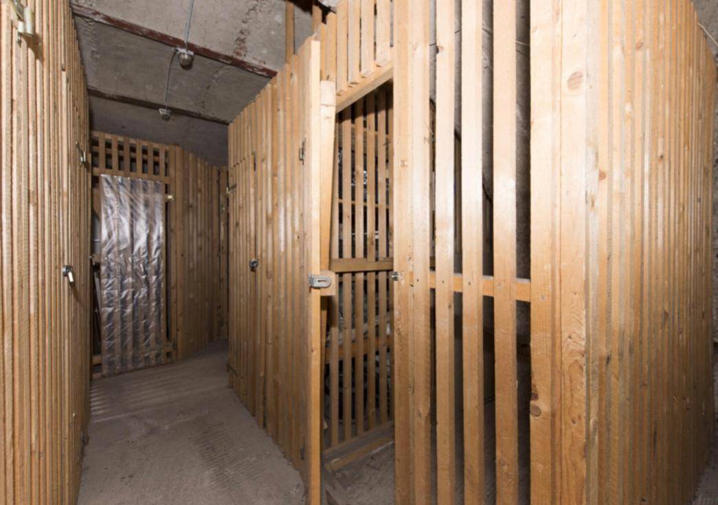 Kellerabteil mit Holzverschlägen für zusätzlichen Stauraum im Untergeschoss des Gebäudes.