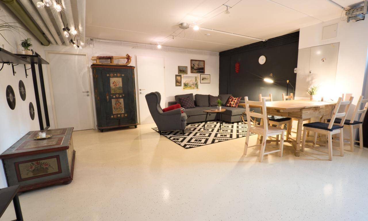 Offener Wohn- und Essbereich mit Holztisch, Sofa und dekorativem Teppich.