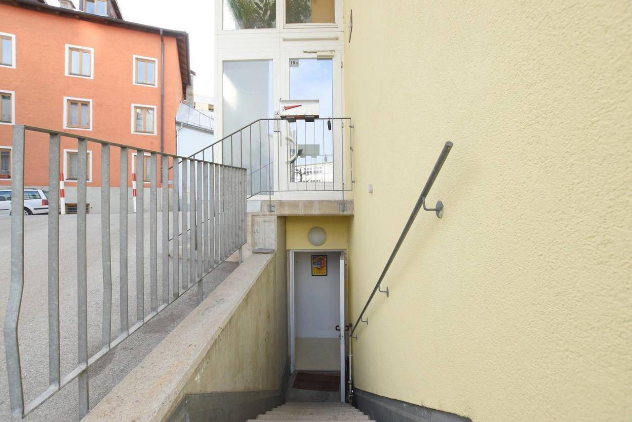 Eingangsbereich zu einer Souterrainwohnung mit Treppe, Rampe und Handlauf.