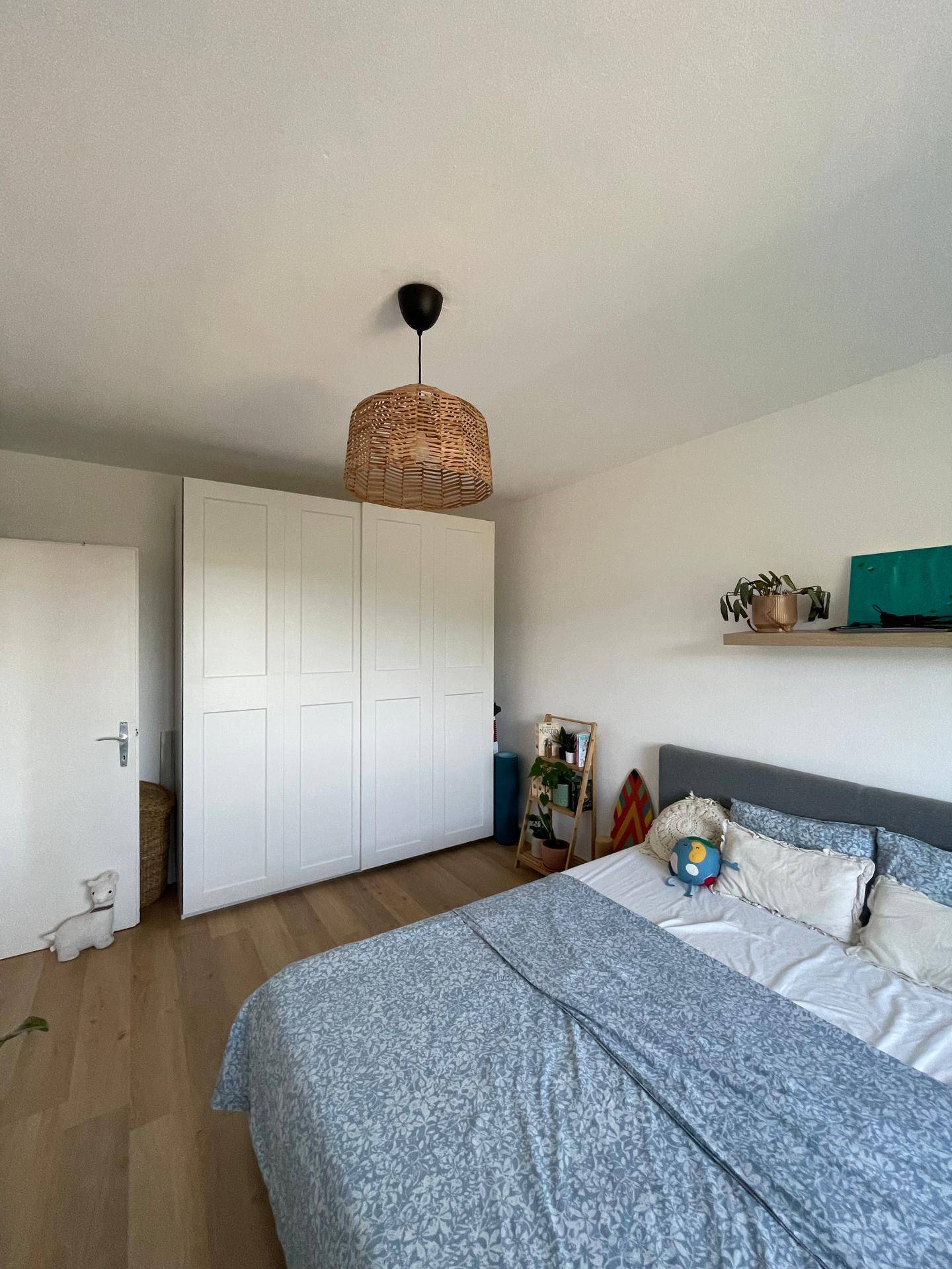 Schlafzimmer mit Holzboden, Doppelbett und weißem Kleiderschrank.