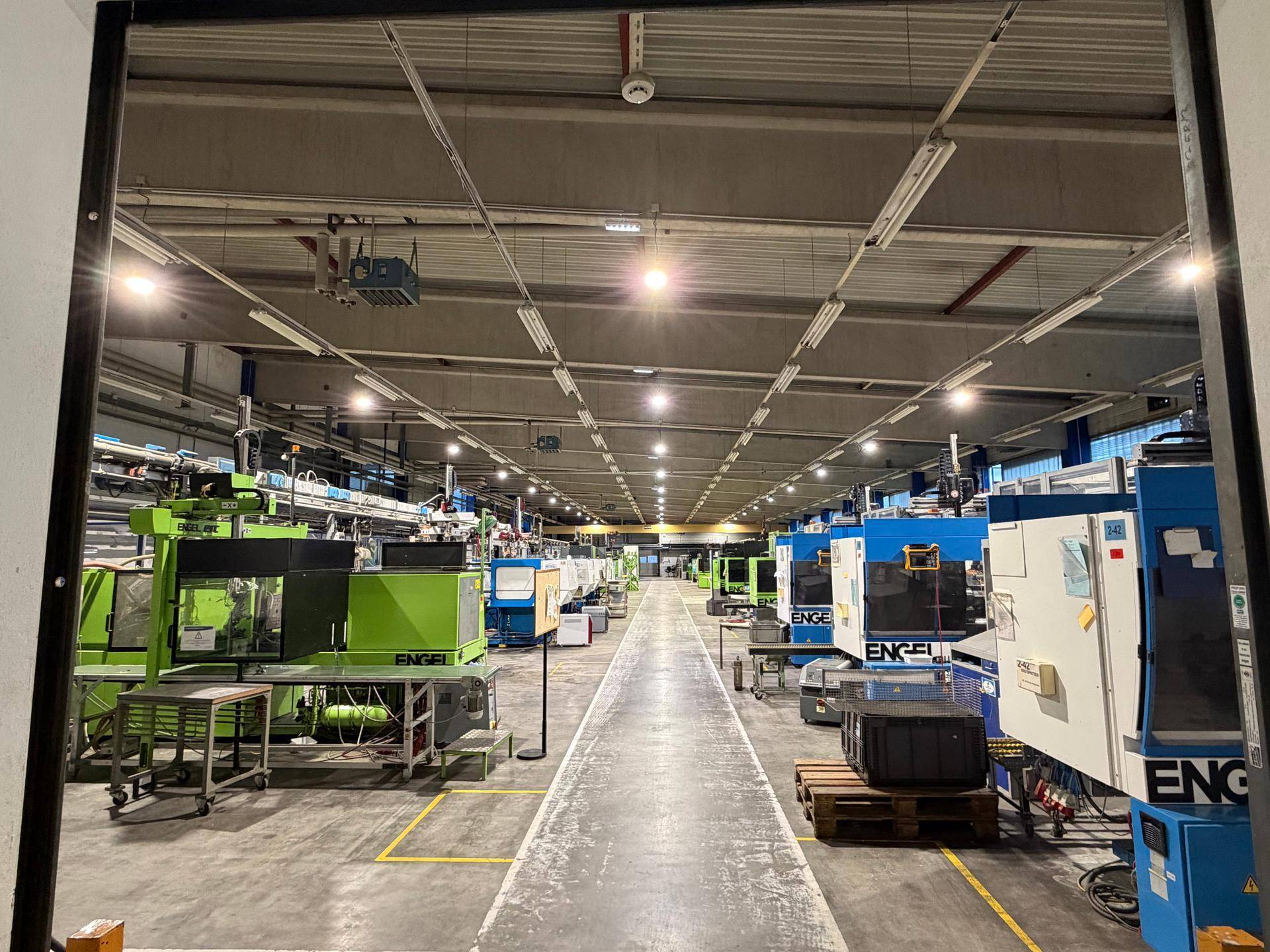 Weitläufige Produktionshalle mit vielen Maschinen, hohen Decken und effizienter Beleuchtung.