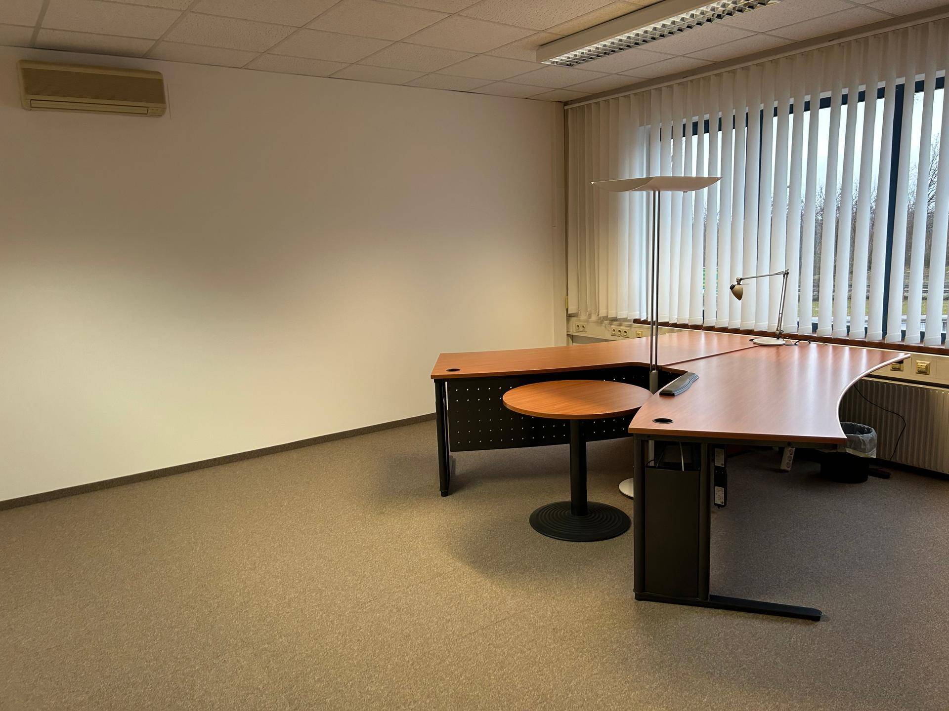 Büro mit Schreibtisch, Bürostuhl und Klimaanlage, bietet eine angenehme Arbeitsumgebung.