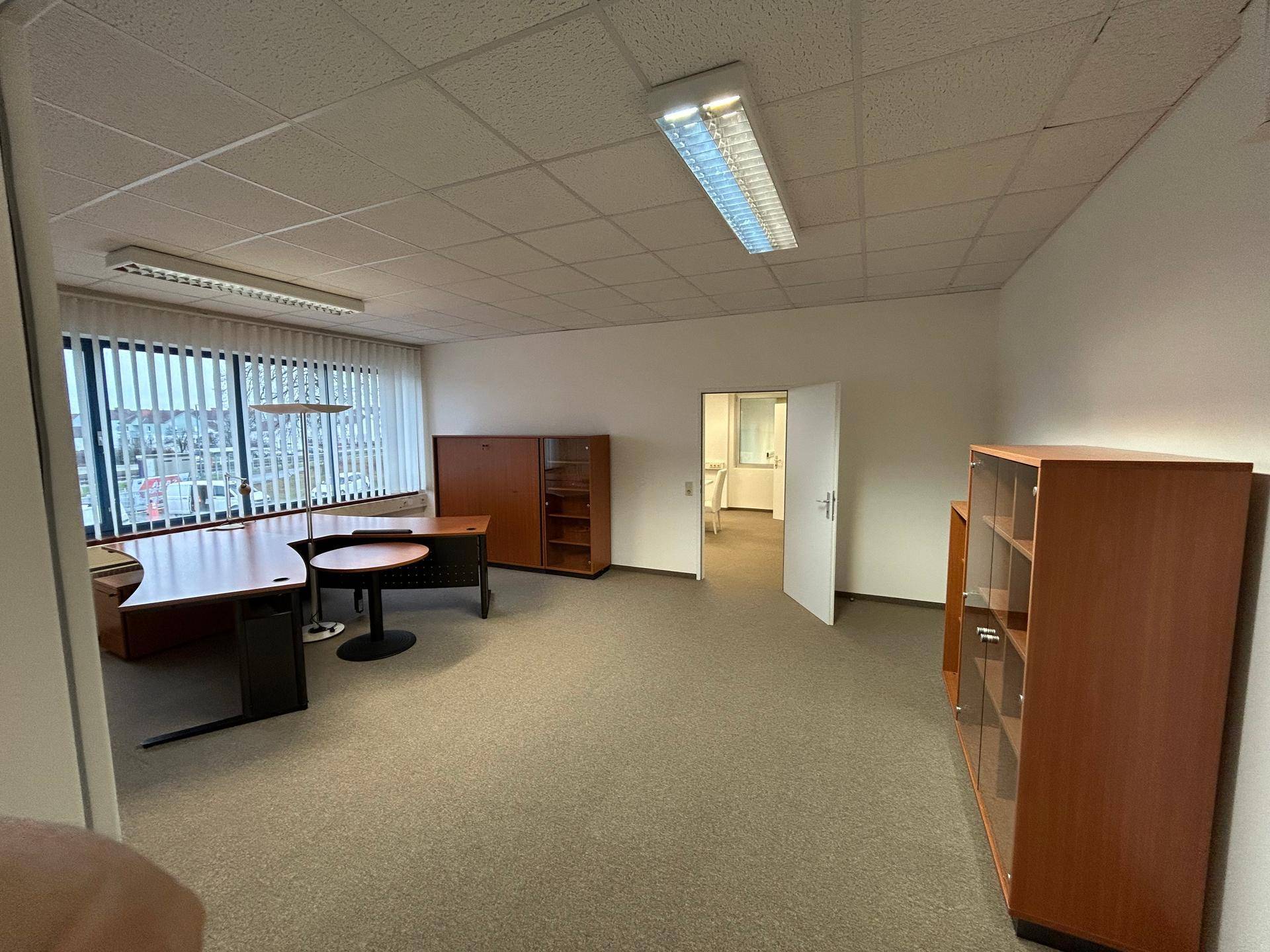 Geräumiges Büro mit Teppichboden, Schreibtischen und Schränken, bereit zur Nutzung.