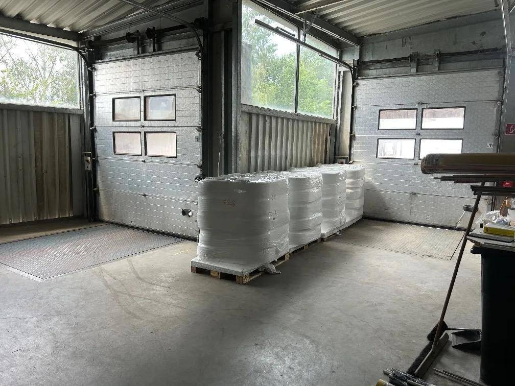 Ladebereich eines Lagerhauses mit Rolltoren und gelagerten Materialien.