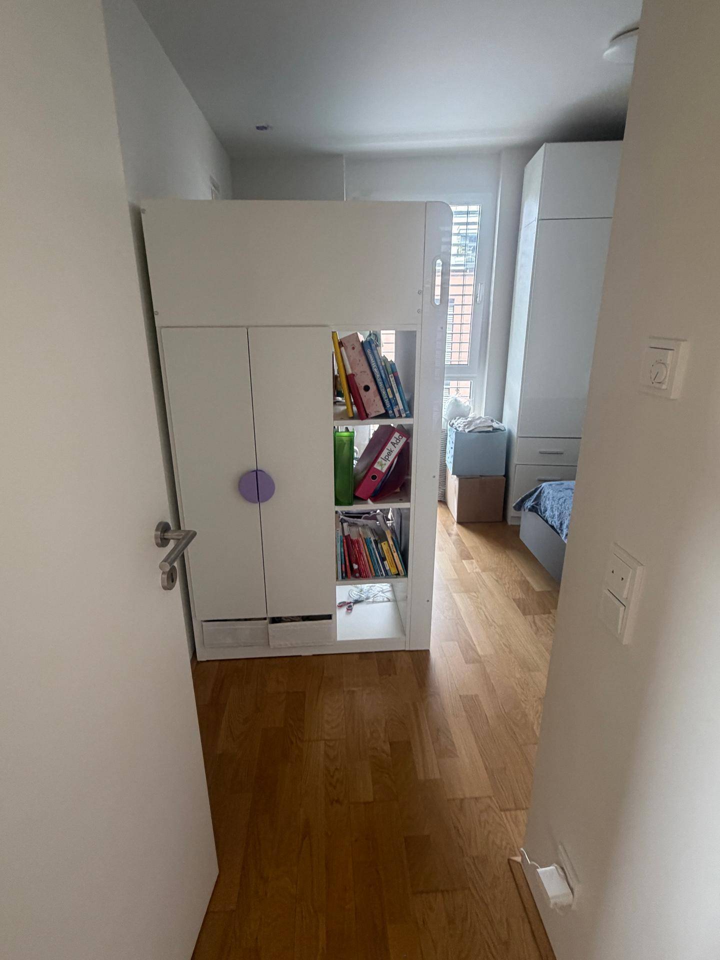 Heller Flur mit praktischem Stauraum und Zugang zu einem Schlafzimmer.
