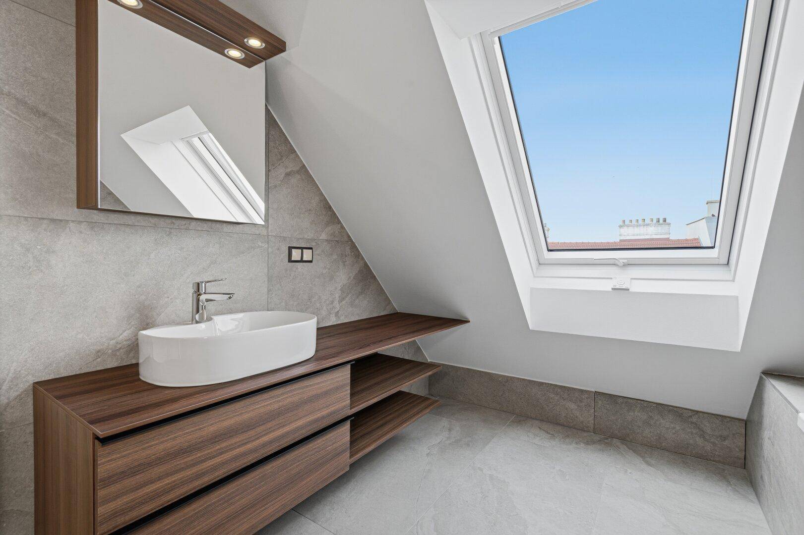 Modernes Badezimmer mit Dachfenster, schwebendem Waschtisch und Spiegelschrank.
