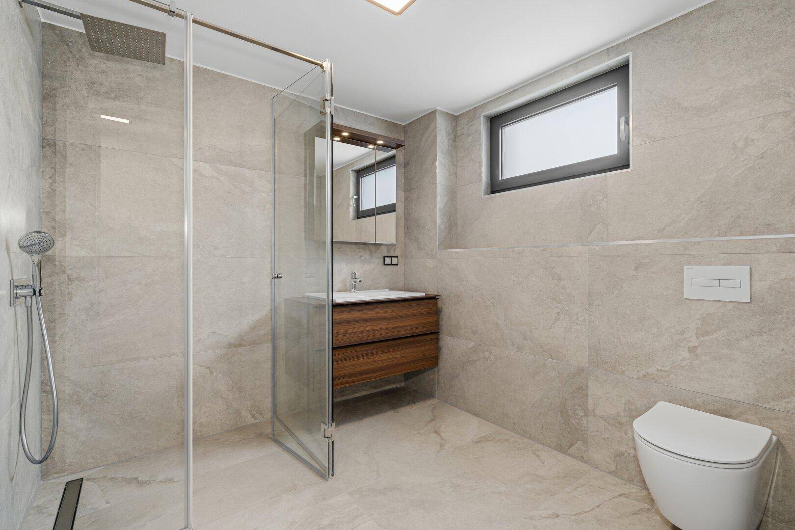 Modernes Badezimmer mit großformatigen Fliesen, ebenerdiger Dusche und schwebendem Waschtisch.
