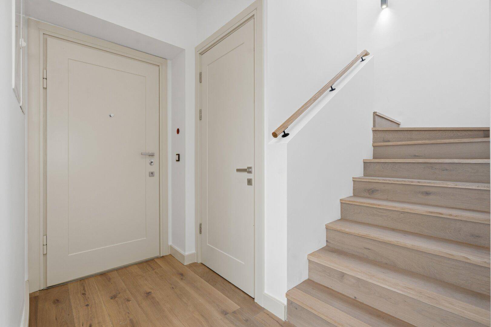 Eingangsbereich mit Holzboden und Treppe, die in die obere Etage führt.