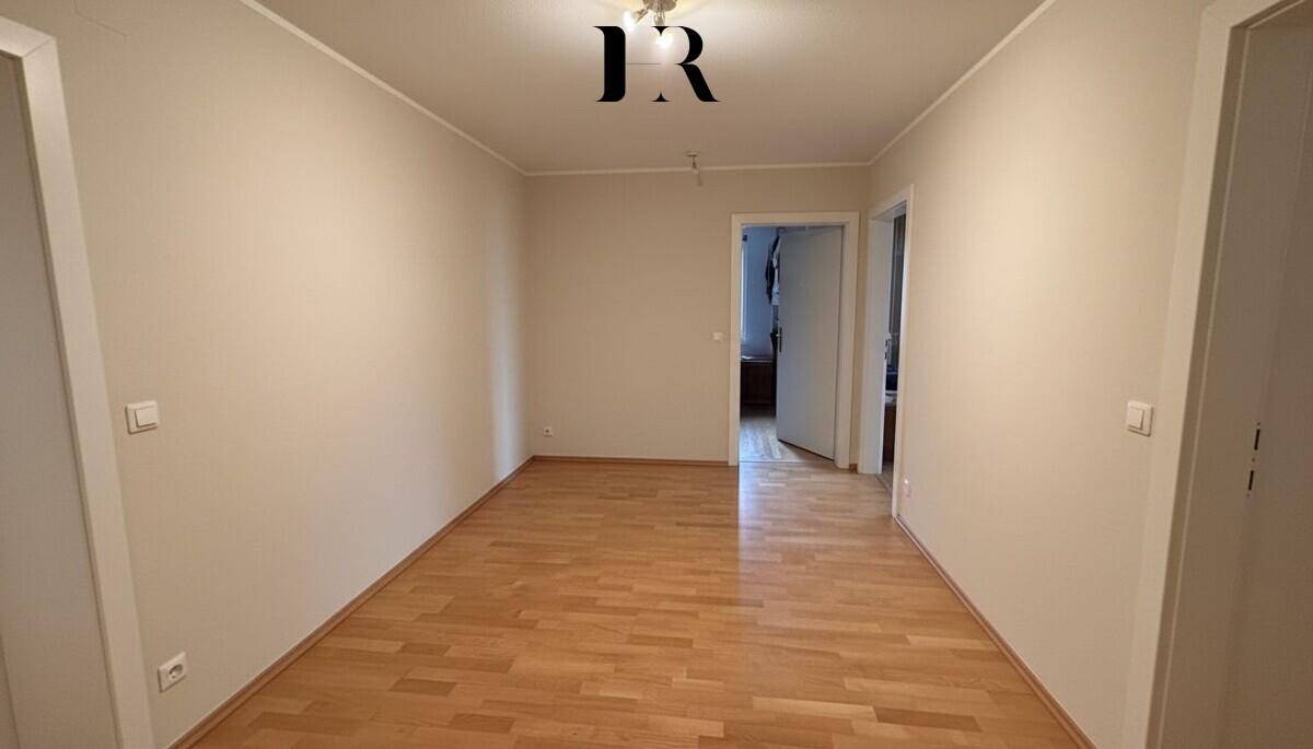 Leeres Zimmer mit Parkettboden und hellem Anstrich, vielseitig nutzbar als Schlaf- oder Arbeitszimmer.