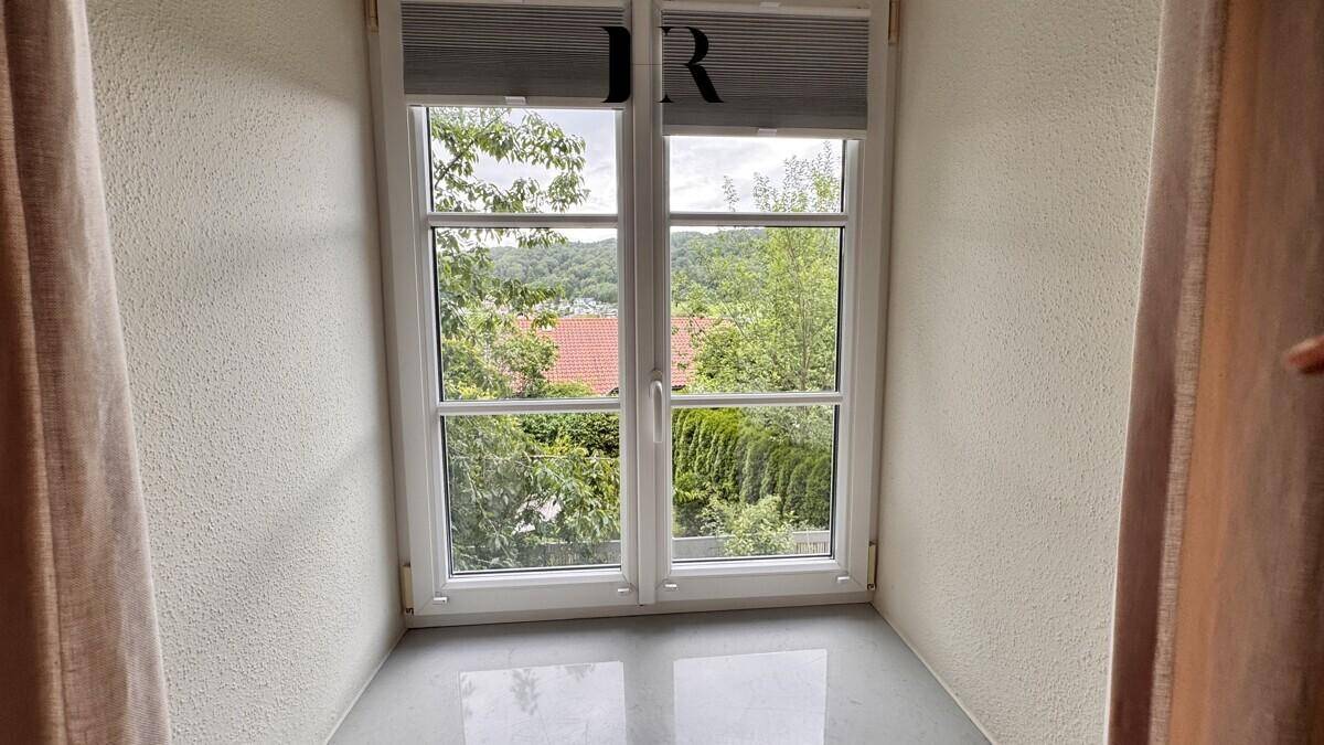 Fenster mit Blick ins Grüne, das viel Tageslicht in den Raum lässt.