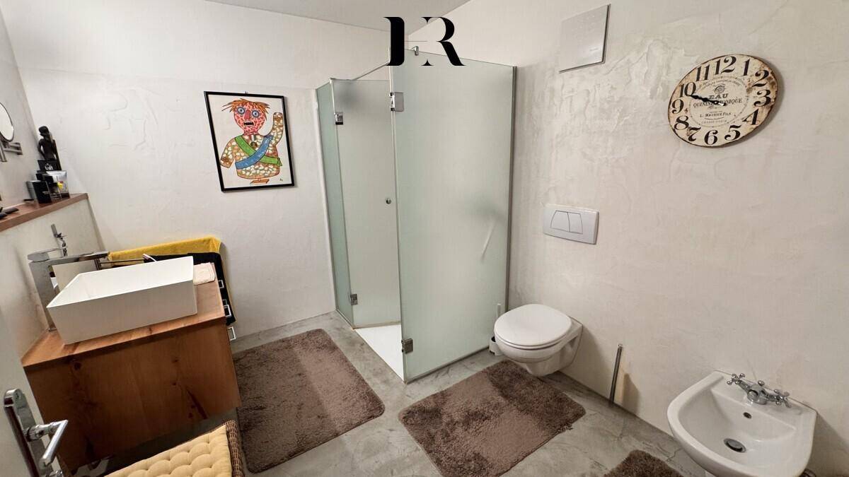 Badezimmer mit Dusche, Toilette und Bidet, ausgestattet mit modernen Armaturen.