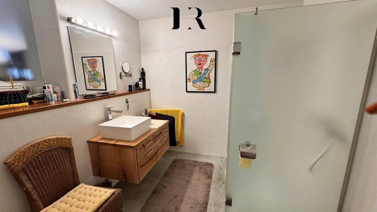 Modernes Badezimmer mit Waschbecken auf Holzunterschrank und begehbarer Dusche.