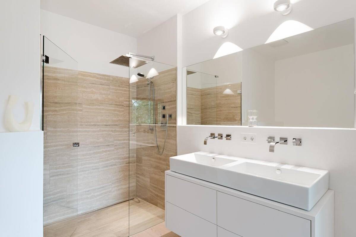 Stilvolles Badezimmer mit Doppelwaschbecken, großer Glasdusche und modernen Armaturen.