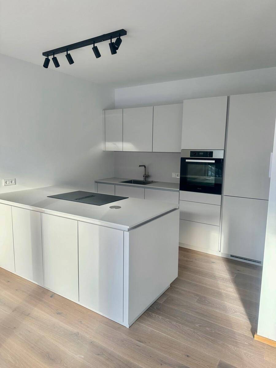 Helle, moderne Einbauküche mit Kücheninsel, Induktionskochfeld und viel Stauraum.