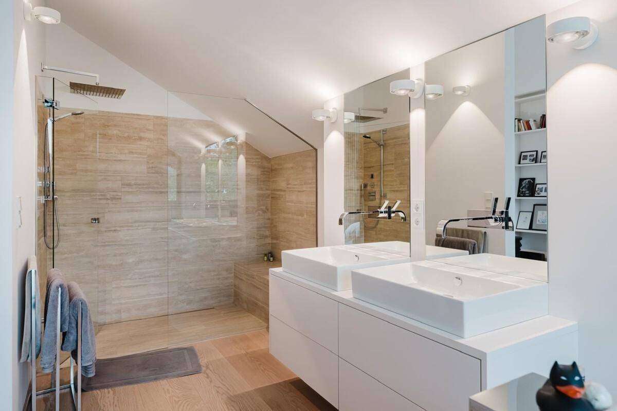 Modernes Badezimmer mit Doppelwaschbecken, großer begehbarer Dusche und Holzboden.