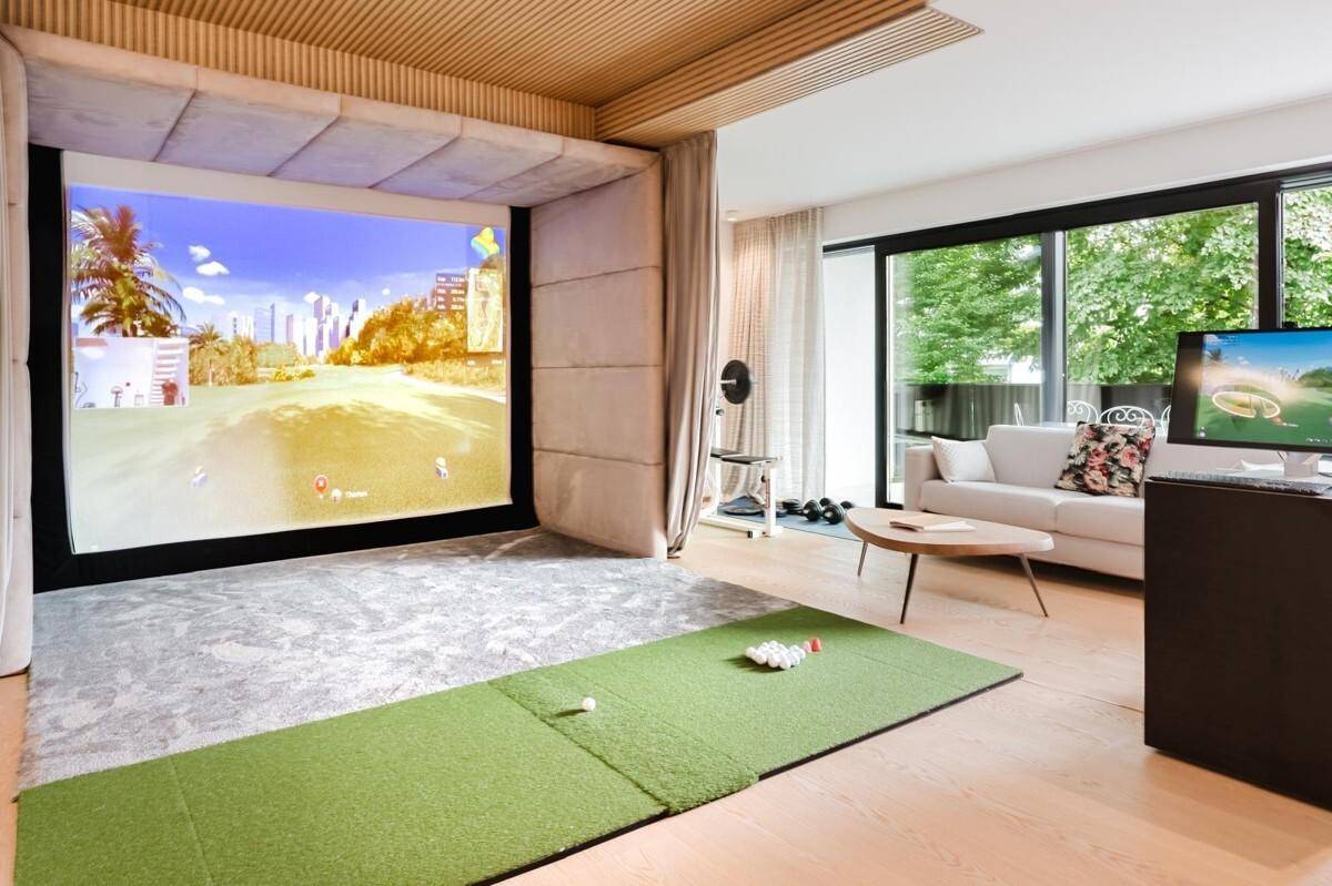 Exklusiver Raum mit Golfsimulator, Sitzbereich und Zugang zur Außenterrasse.