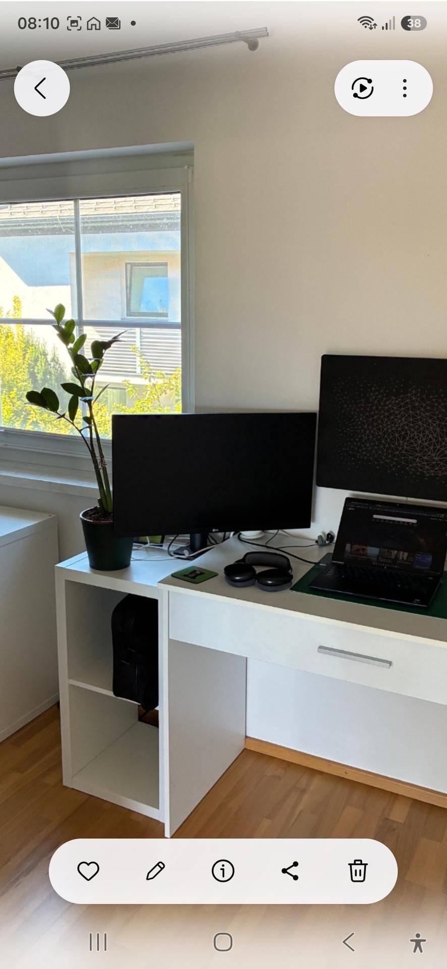 Funktionaler Arbeitsbereich mit Schreibtisch, Computer und natürlichem Lichteinfall durch das Fenster.