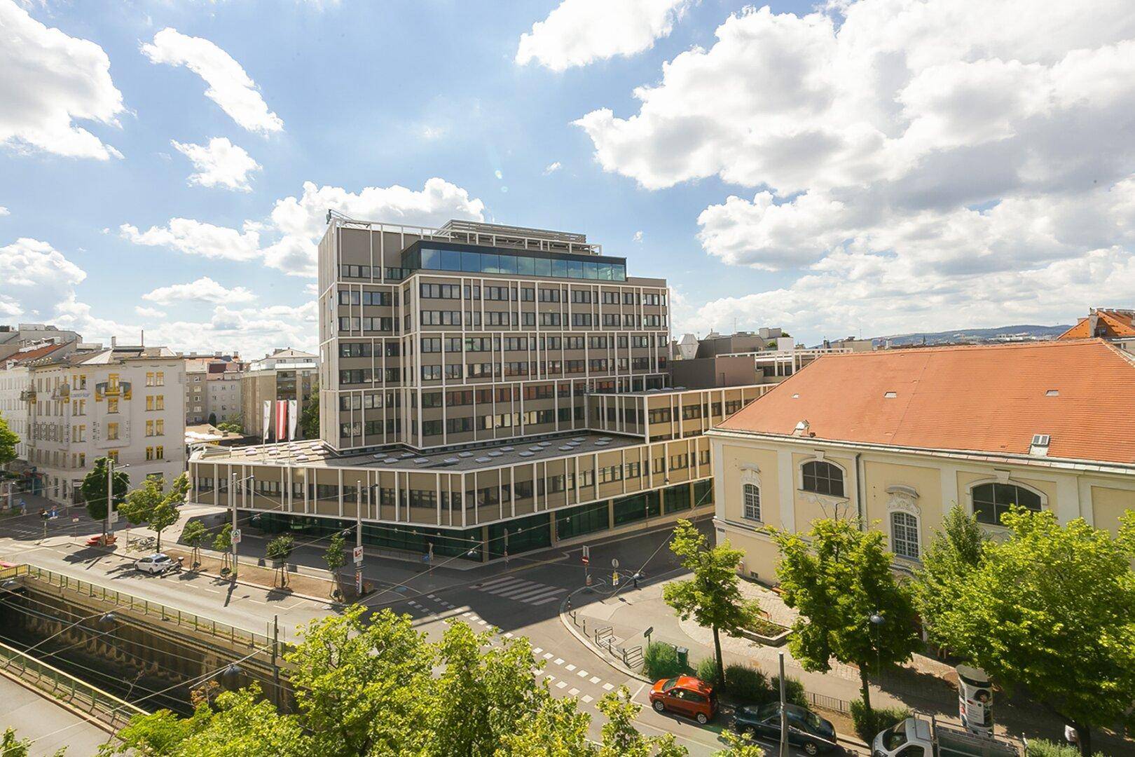 Panoramablick über die Stadt mit modernen Gebäuden und historischer Architektur unter blauem Himmel.