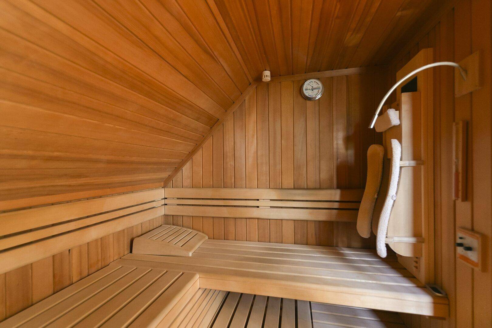 Gemütliche Holzsauna mit Bänken und traditionellem Design für Entspannung.