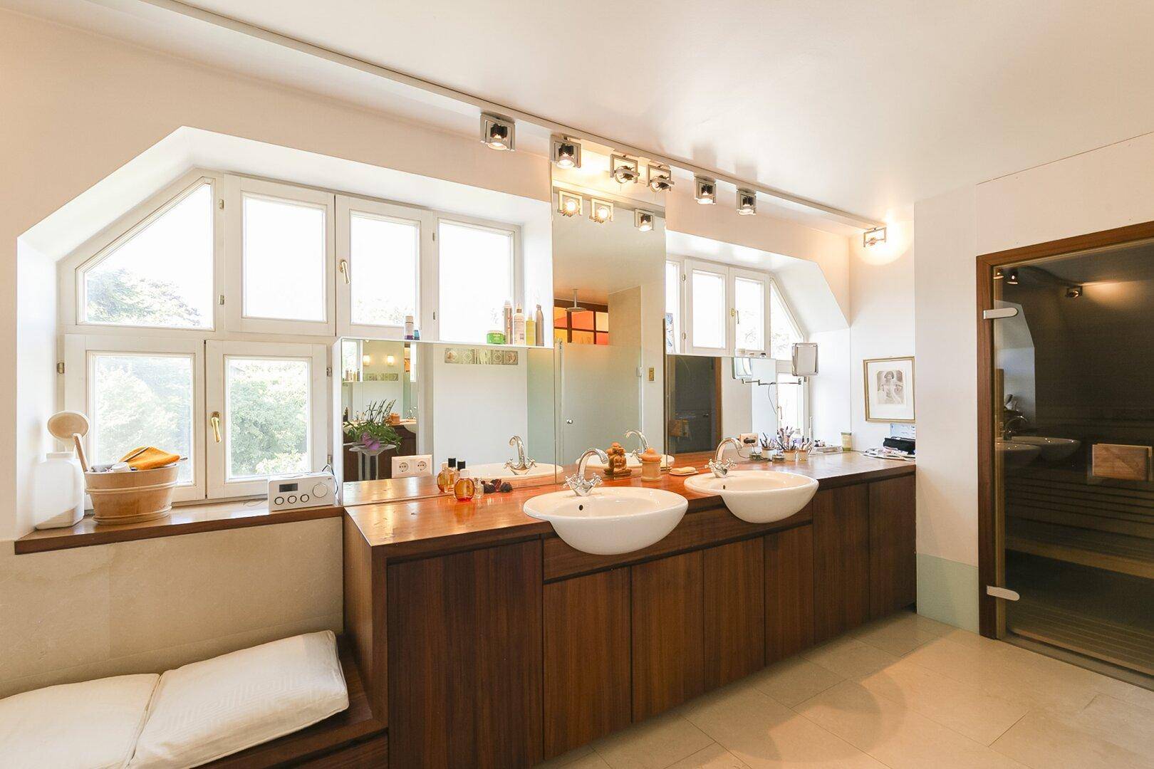 Geräumiges Badezimmer mit Doppelwaschbecken, Holzwaschtisch und integrierter Sauna.