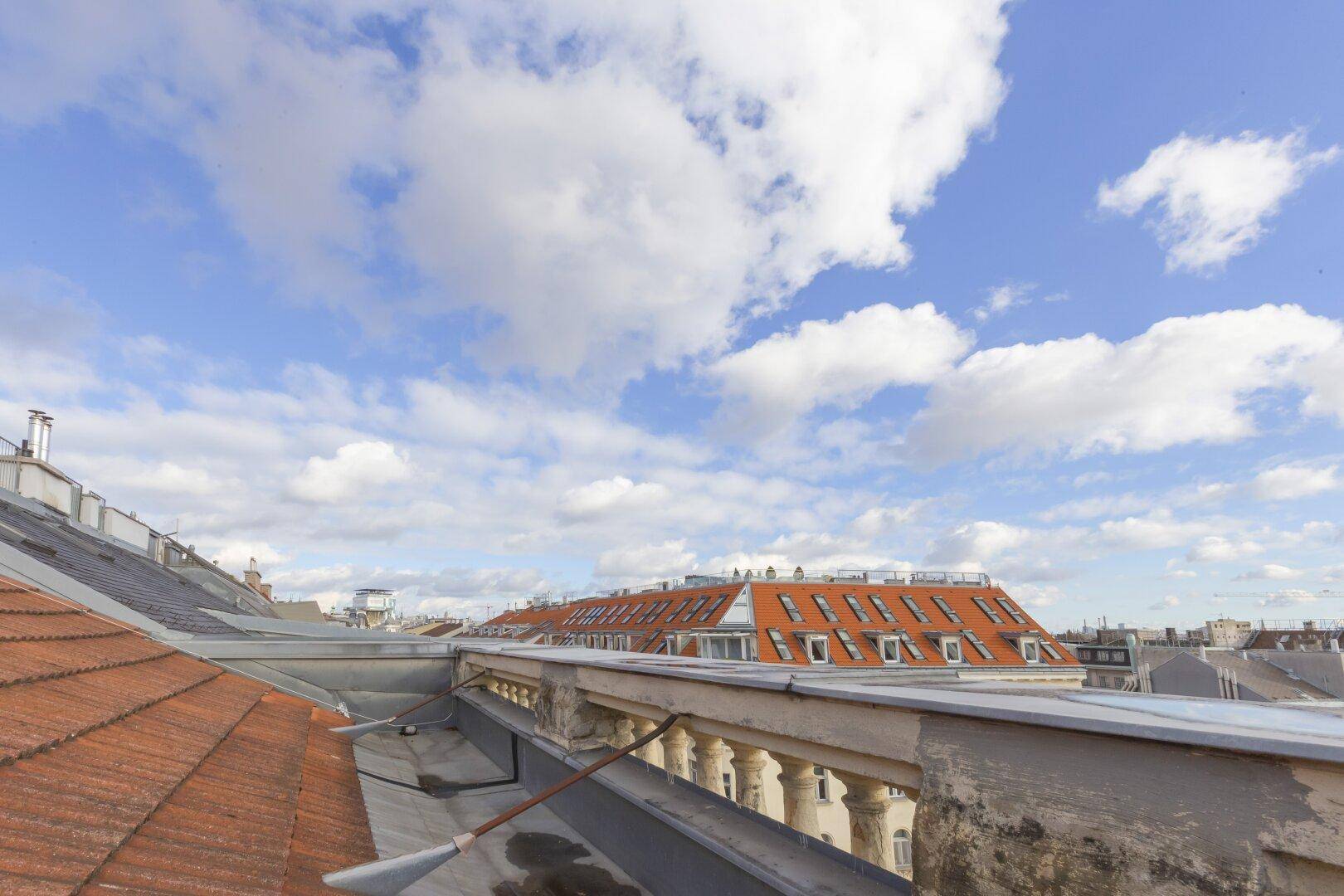Panoramablick über die Dächer der Stadt mit historischen Gebäuden und weitem Himmel.