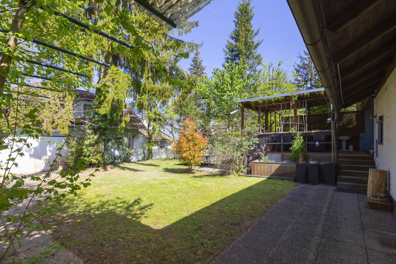 Großer, gepflegter Garten mit Rasenfläche und Bäumen, ideal zum Entspannen.