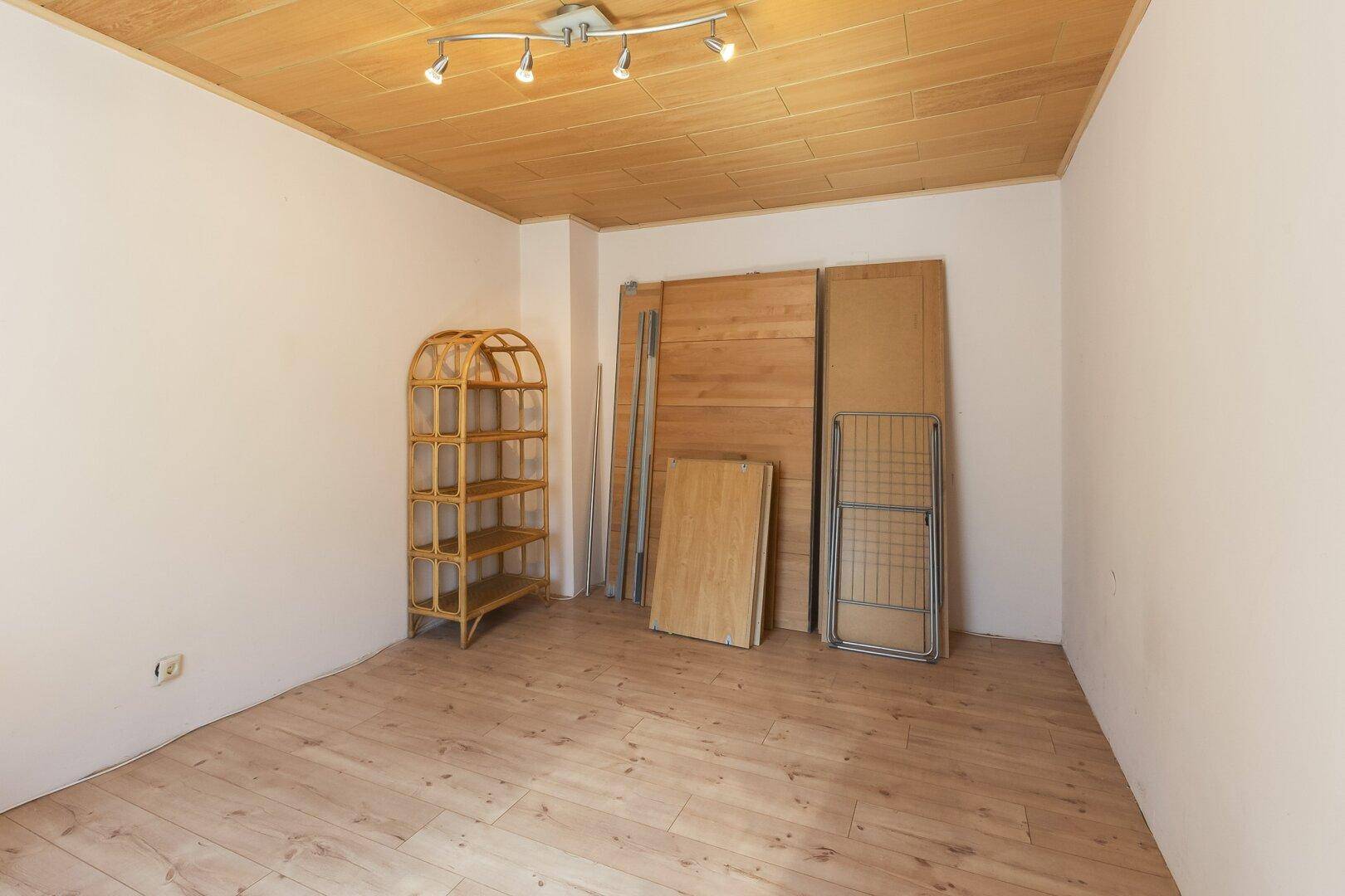 Geräumiger Abstellraum mit Holzboden und Holzpaneelen, ideal für Lagerzwecke.