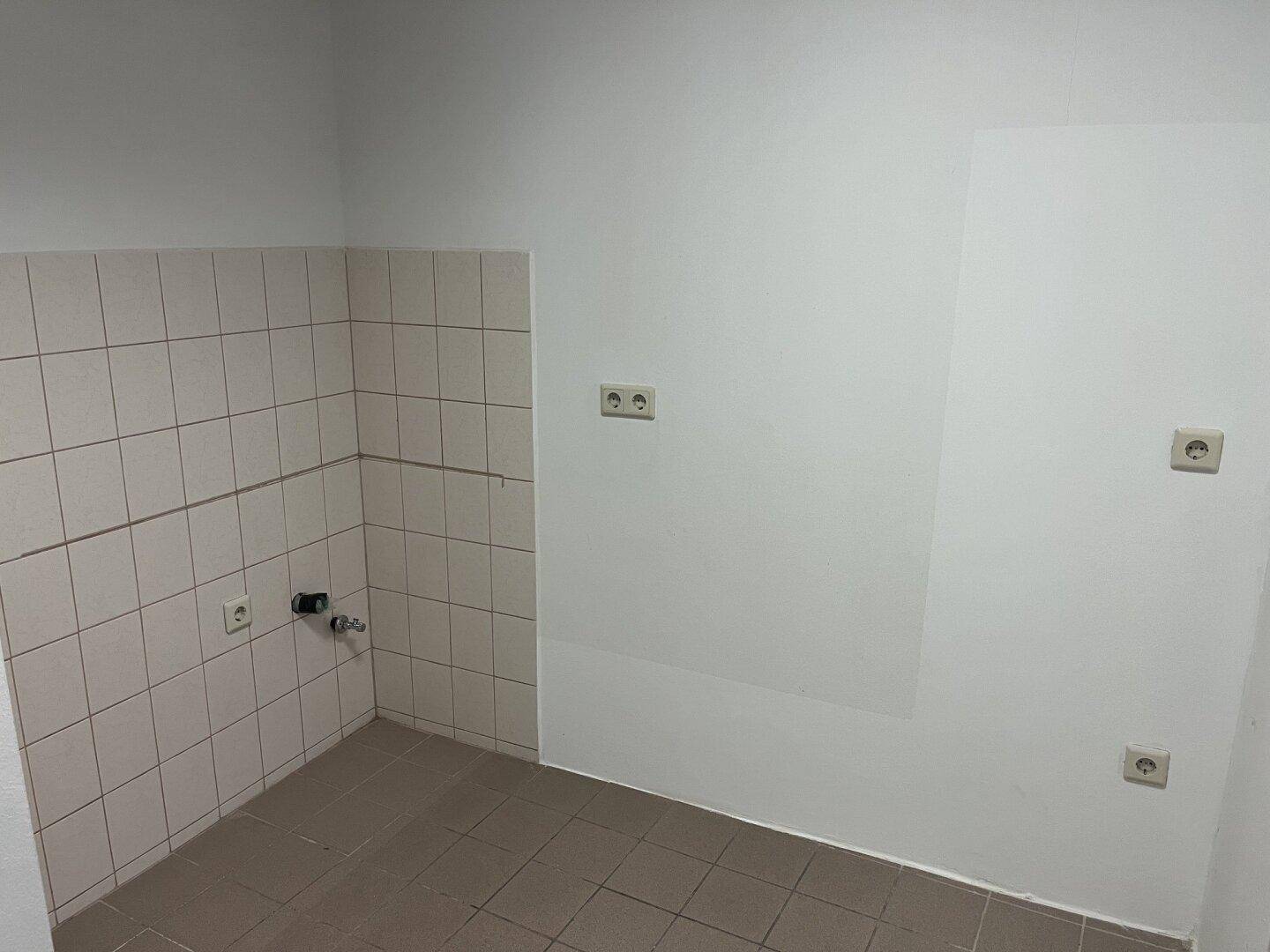 Ein kleiner Raum mit gefliesten Wänden und Boden, vorbereitet für Installationen.