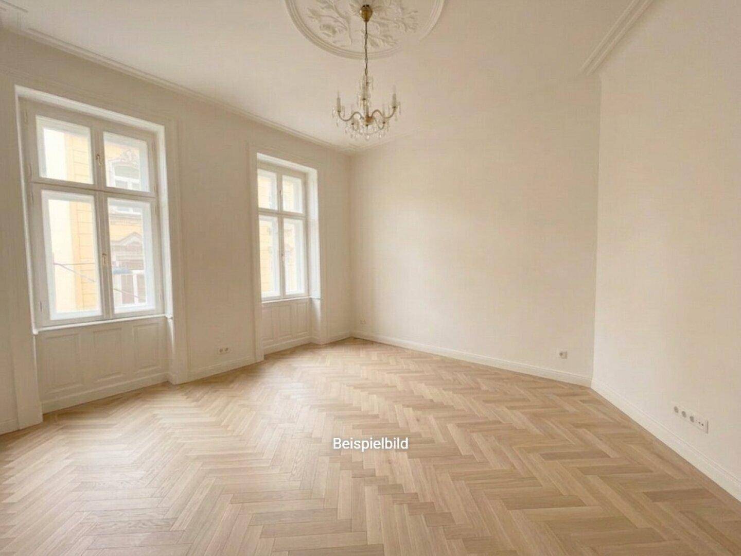 Elegantes Zimmer mit Fischgrätparkett, Stuckdecke und Kronleuchter, der eine klassische Atmosphäre schafft.