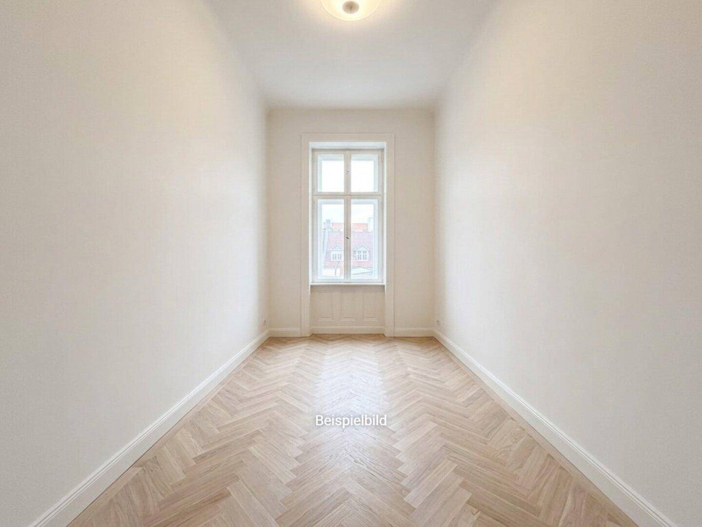 Schmaler, heller Raum mit Fischgrätparkett und einem hohen Fenster, ideal als Arbeitszimmer.