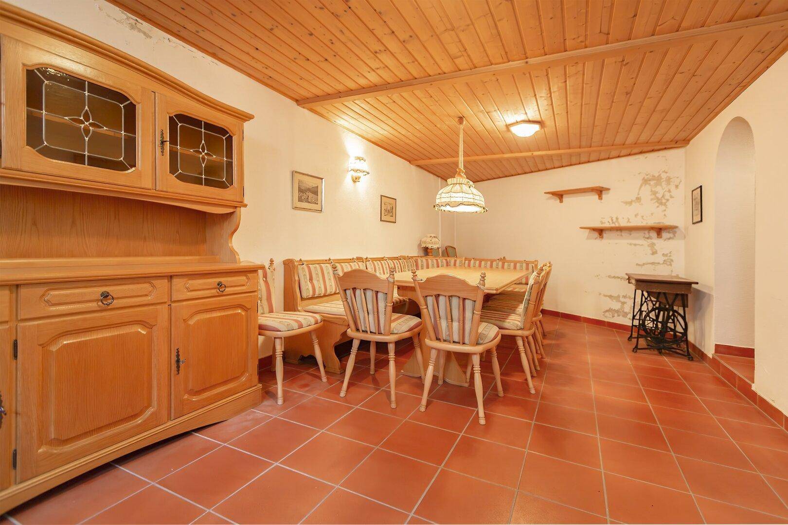 Traditioneller Essbereich mit Holzmöbeln, Eckbank und Terrakottafliesen.