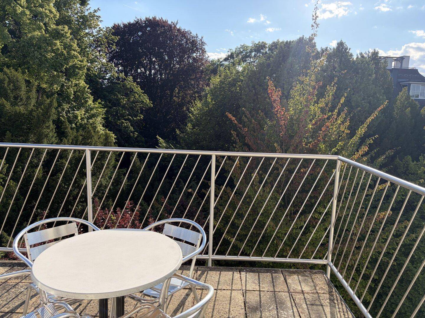 Möblierter Balkon mit Sitzgelegenheiten und weitem Blick ins Grüne.