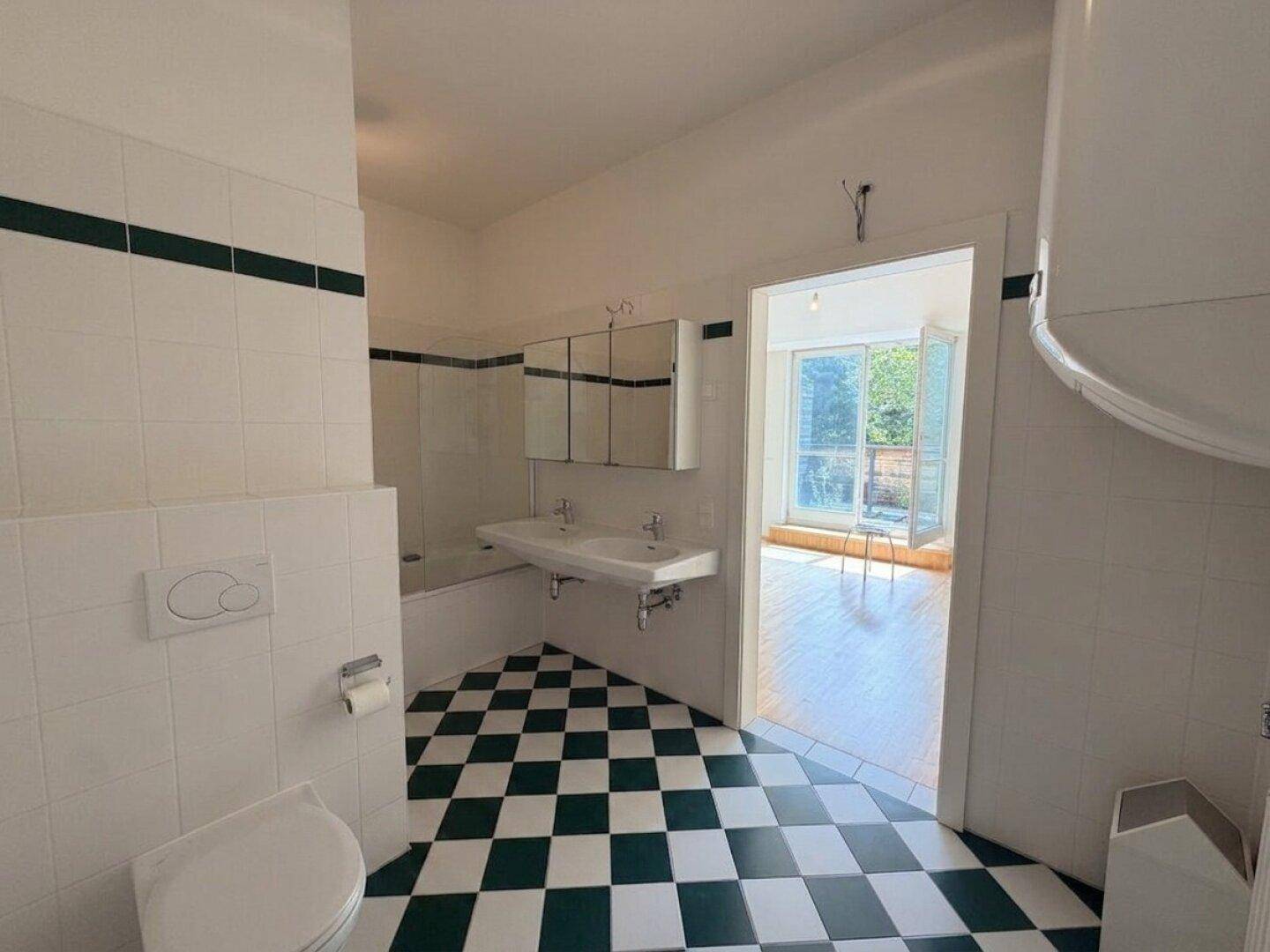 Geräumiges Badezimmer mit Doppelwaschbecken, Badewanne und einem Spiegelschrank.