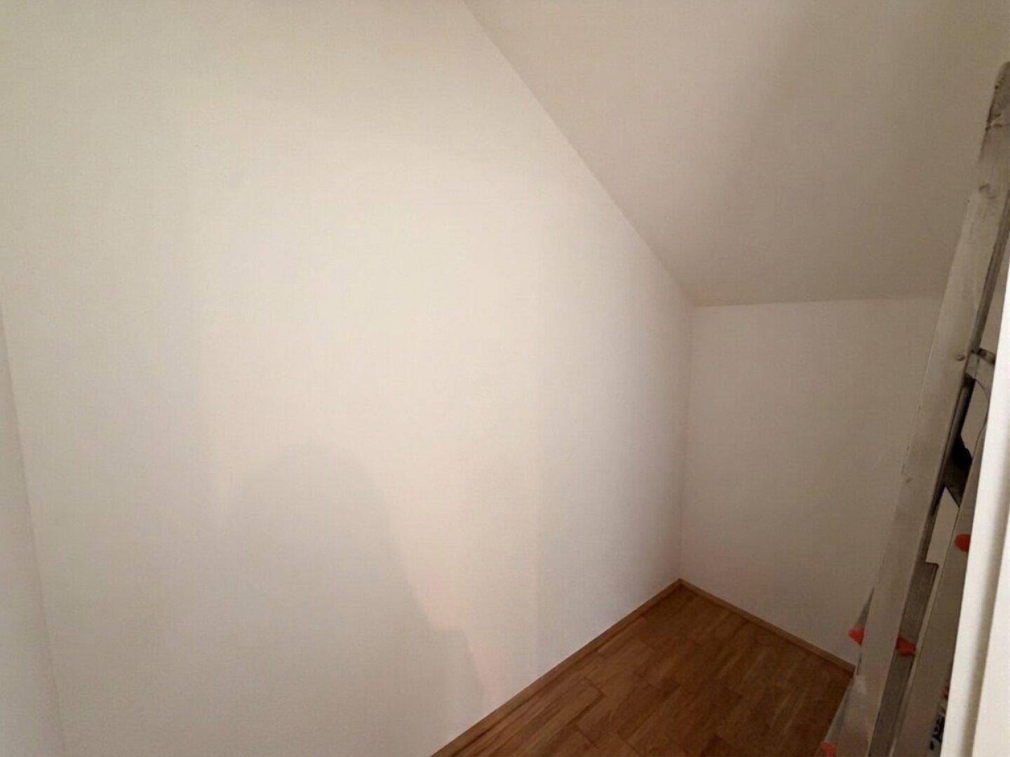 Kleiner Abstellraum mit Dachschräge und Holzboden, ideal für zusätzlichen Stauraum.