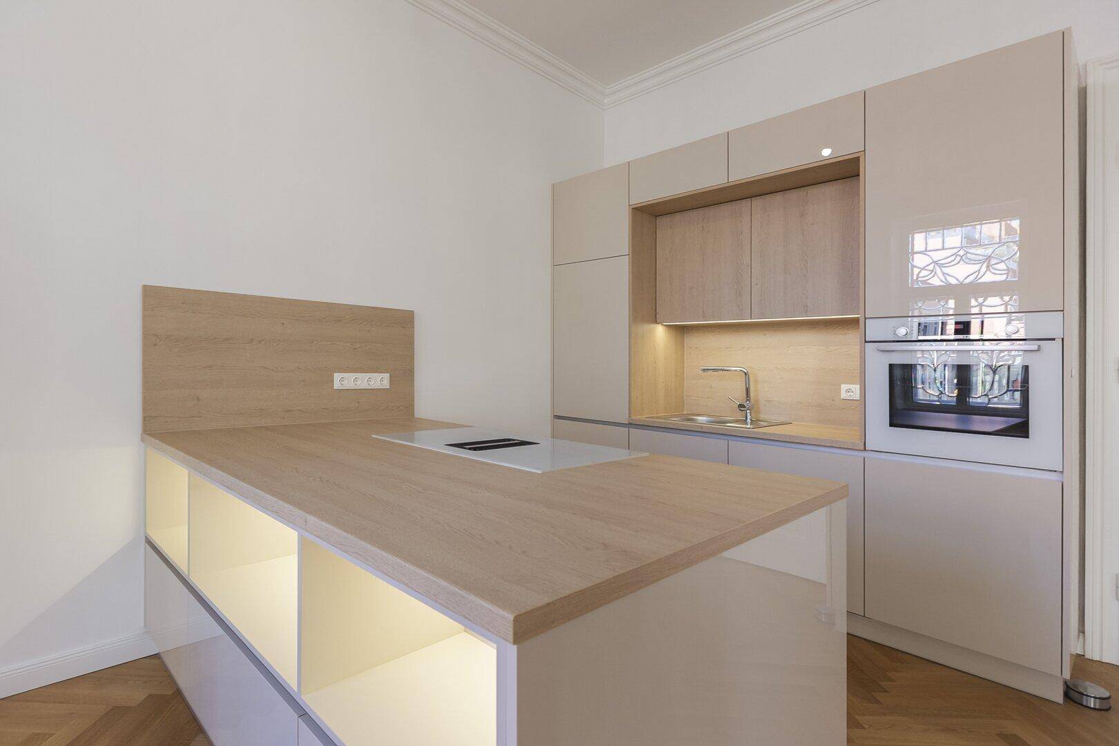 Moderne Kücheninsel mit integriertem Kochfeld und Holz-Arbeitsplatte in hellem Design.