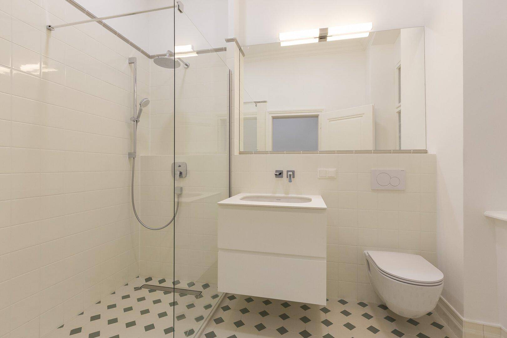 Modernes Badezimmer mit ebenerdiger Dusche, Einzelwaschbecken und Toilette.