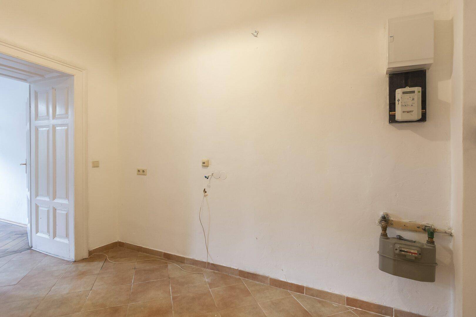 Raum mit Fliesenboden und Wandinstallationen für Versorgungsleitungen, ideal als Abstellraum.