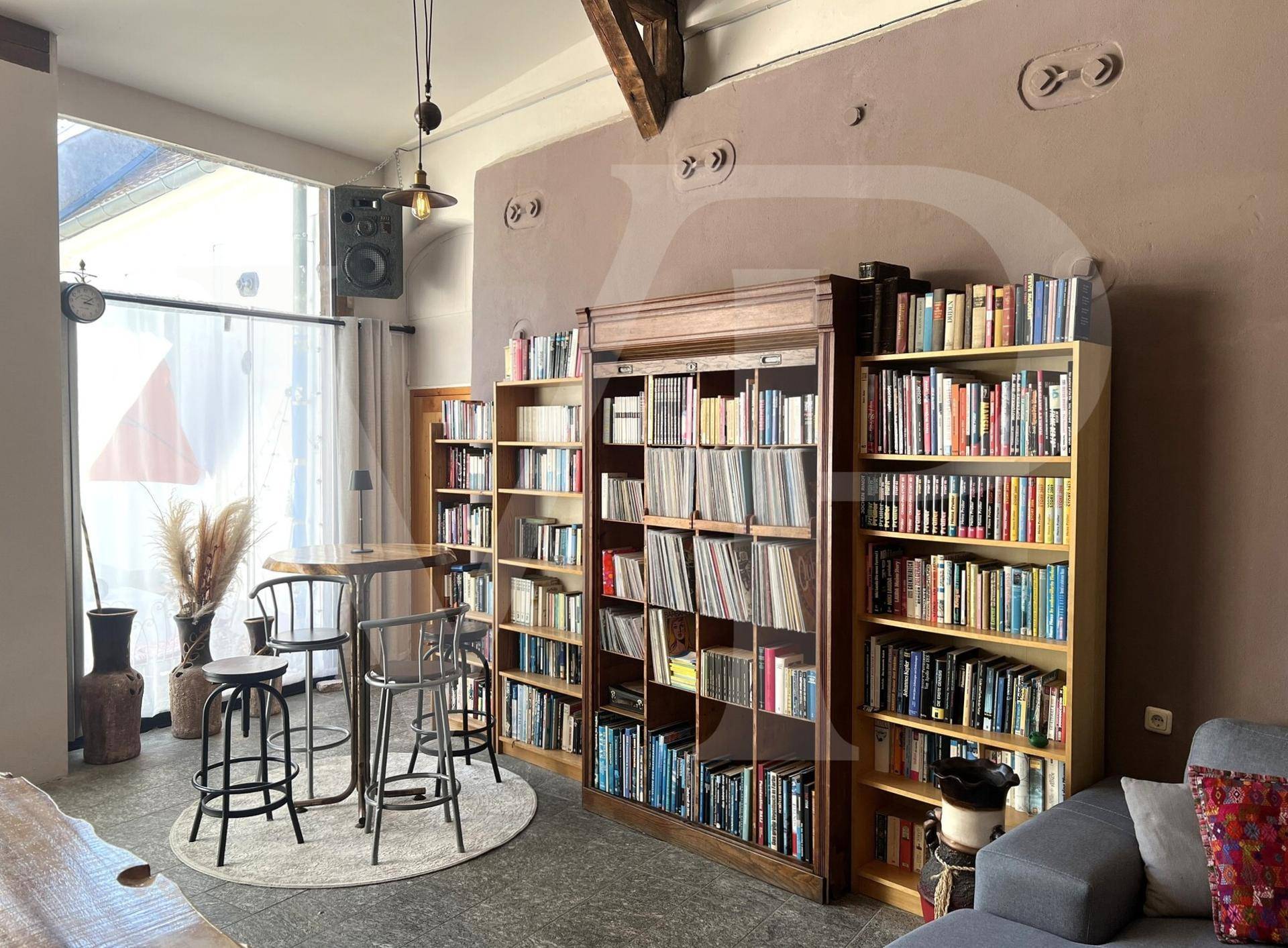Gemütlicher Wohnbereich mit Bücherregalen, einer Sitzecke und bequemen Sofas.