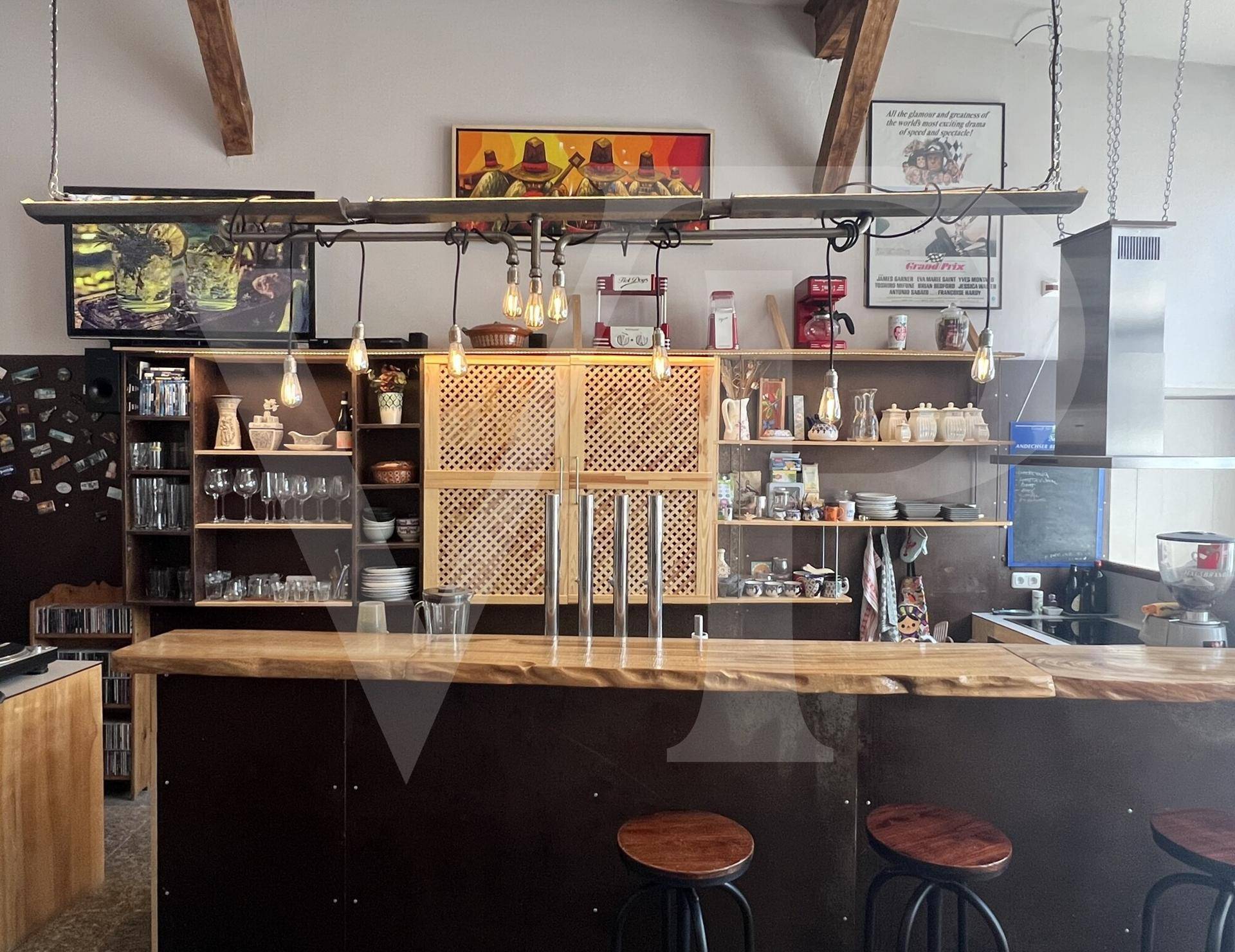 Detailansicht des Barbereichs mit Zapfanlage, Regalen und Kaffeemaschine.