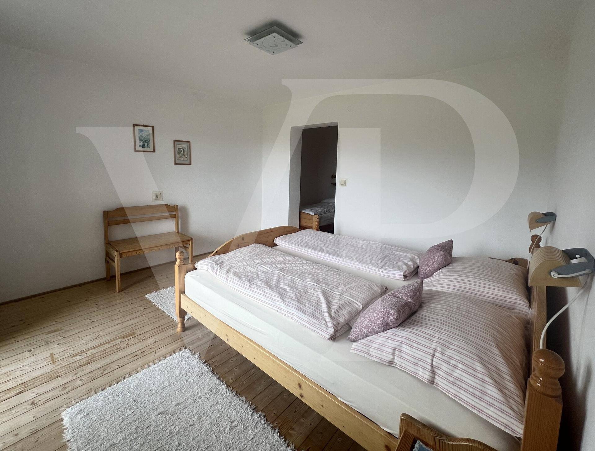 Helles Schlafzimmer mit zwei Einzelbetten, Holzboden und schlichter Einrichtung.