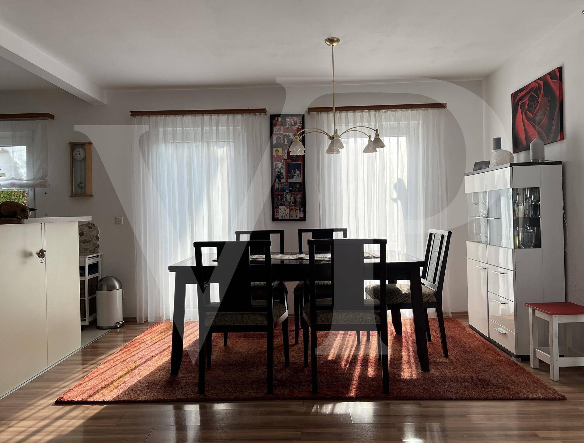 Heller Essbereich mit großem Esstisch, Holzfußboden und Zugang zum Außenbereich.