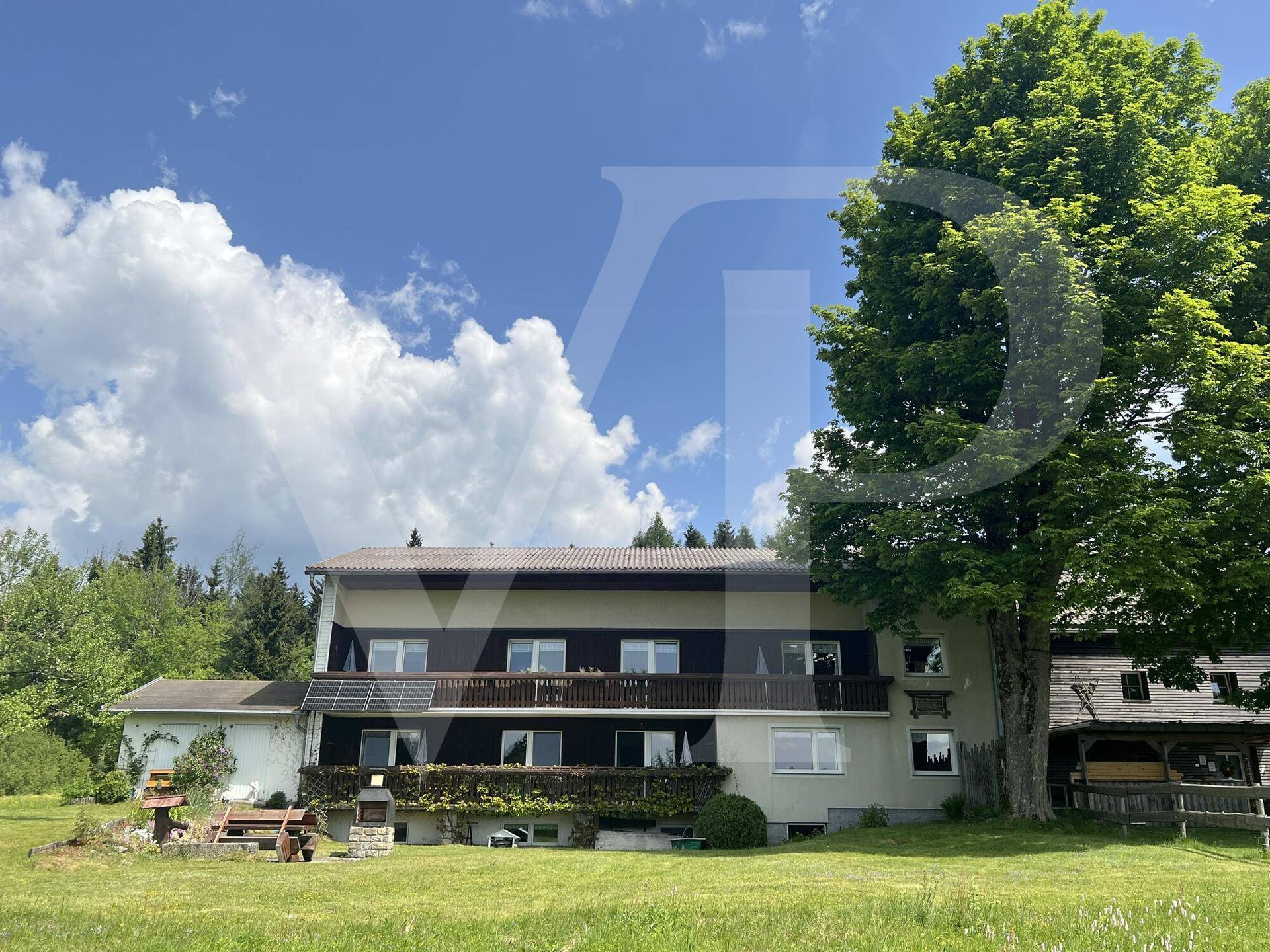 Rückseite des Hauses mit mehreren Balkonen und installierten Photovoltaik-Modulen.