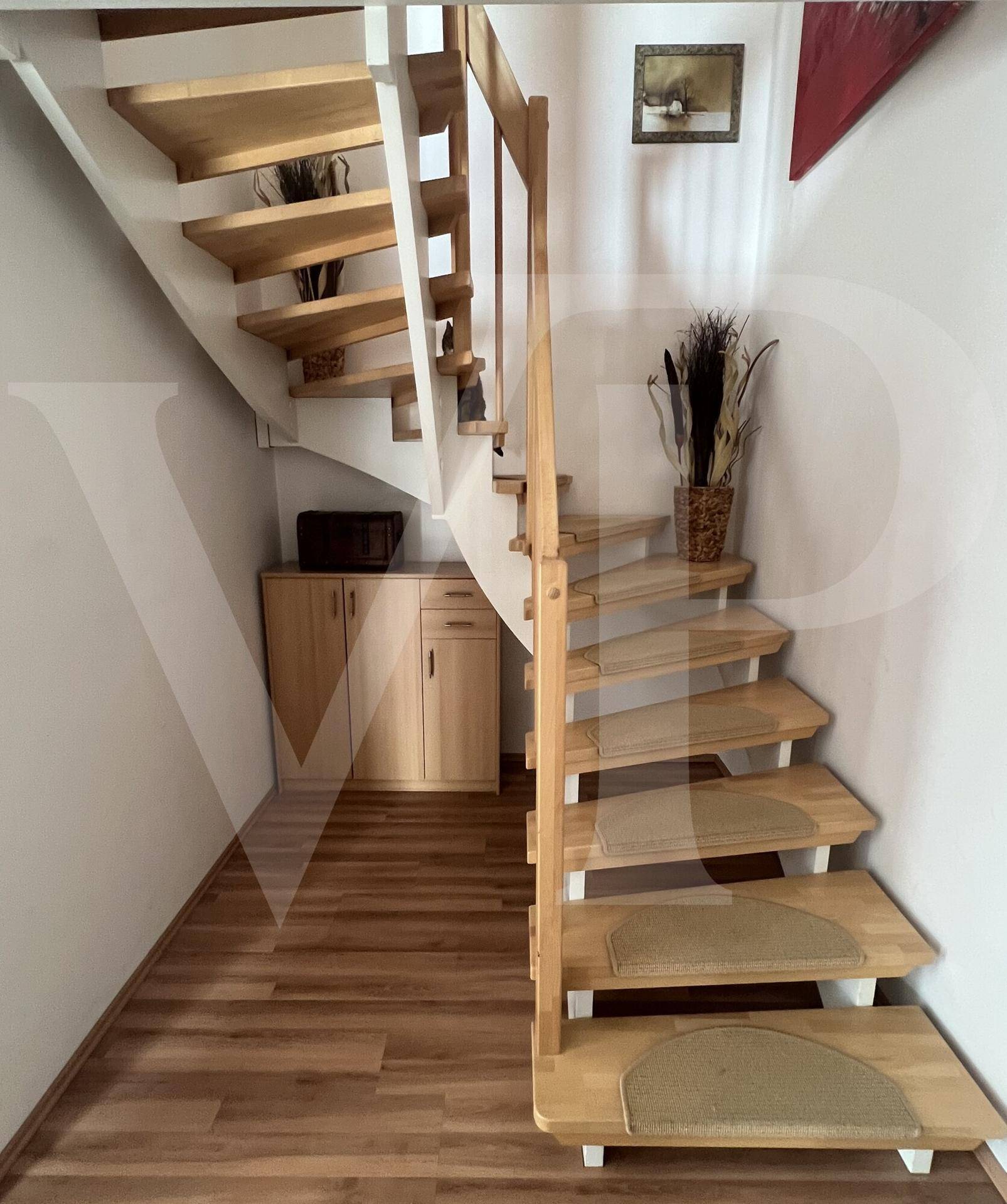 Helle Holztreppe führt in die obere Etage, mit Stauraum darunter.