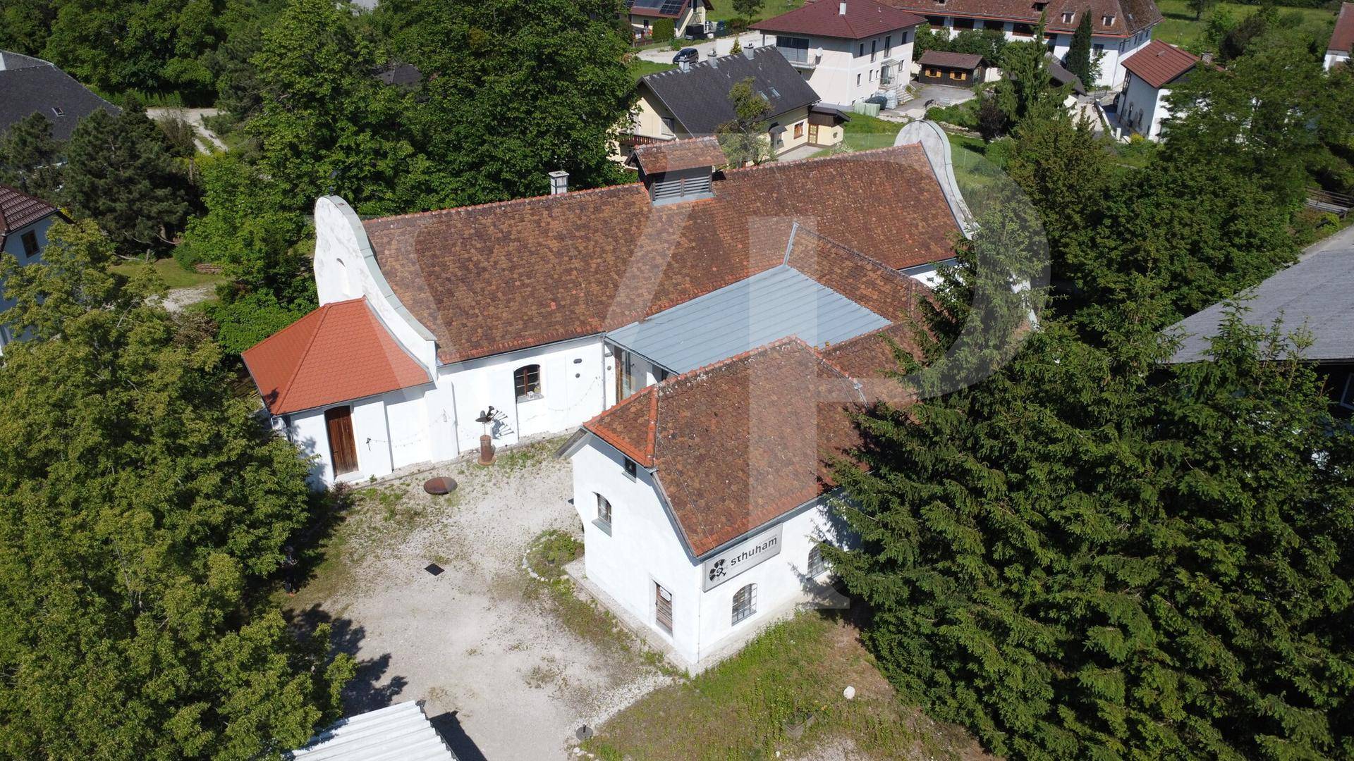 Panoramablick aus der Luft auf das historische Anwesen, eingebettet in eine grüne Landschaft.