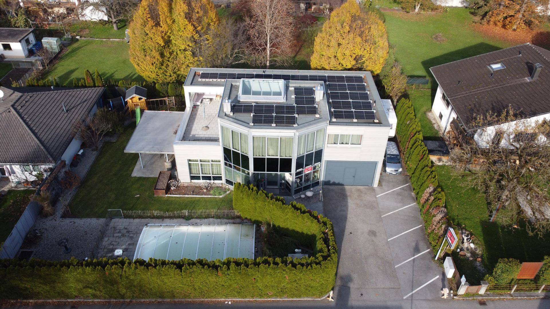 Luftaufnahme des modernen Hauses mit Solaranlage, Pool und gepflegtem Gartenbereich.