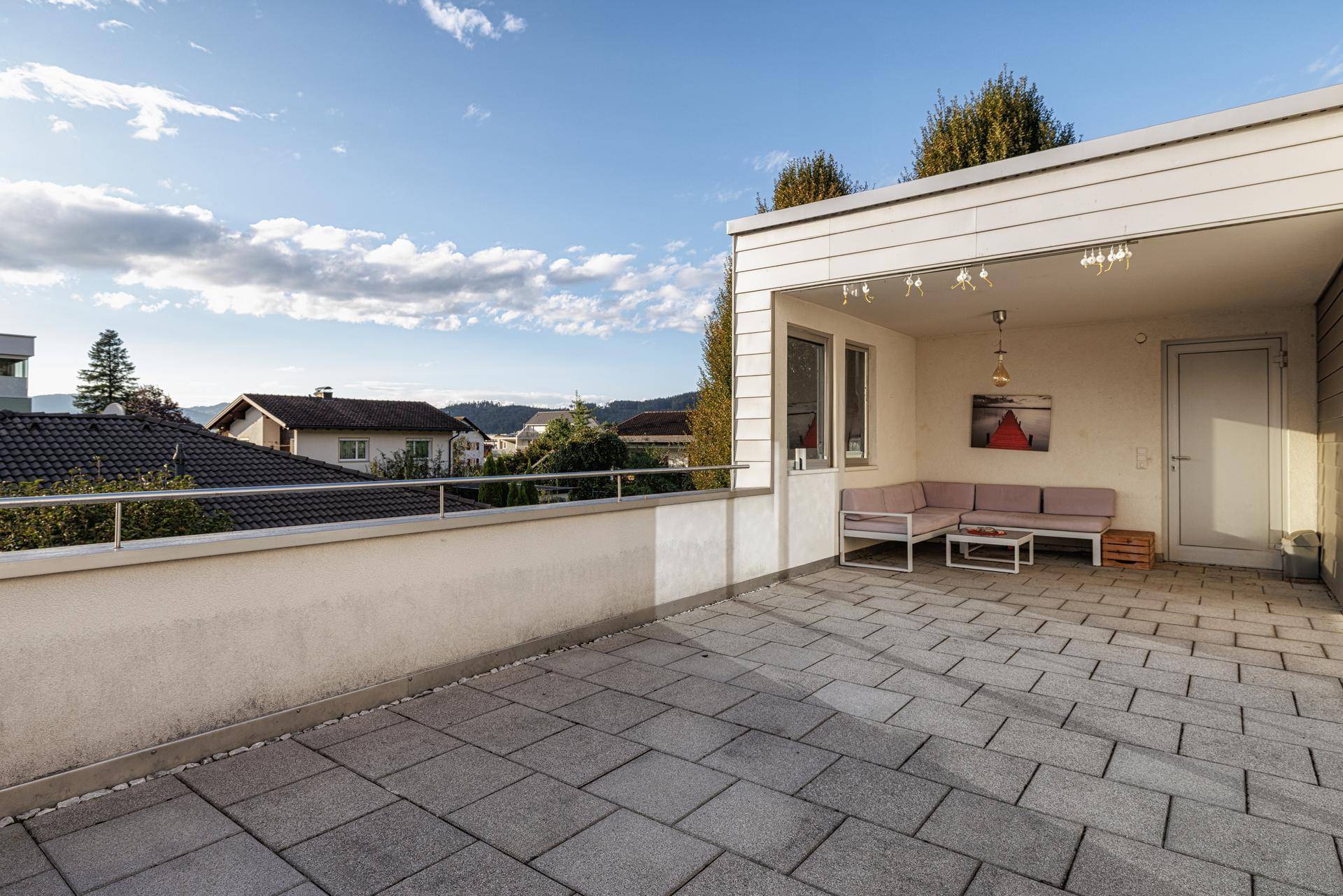 Geräumige überdachte Terrasse mit Sitzgelegenheiten und weitem Blick über die Umgebung.