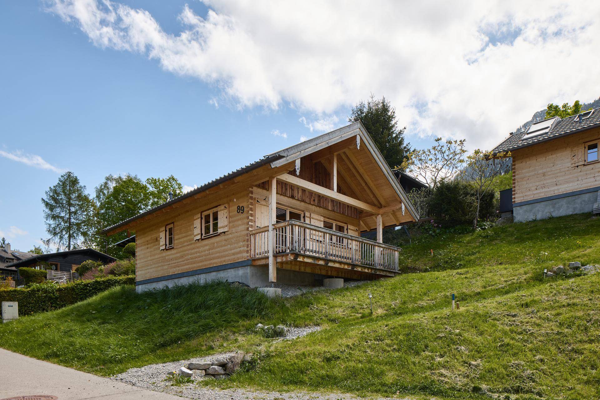 Charmantes Holzchalet mit traditioneller Architektur und Balkon in sonniger Hanglage.